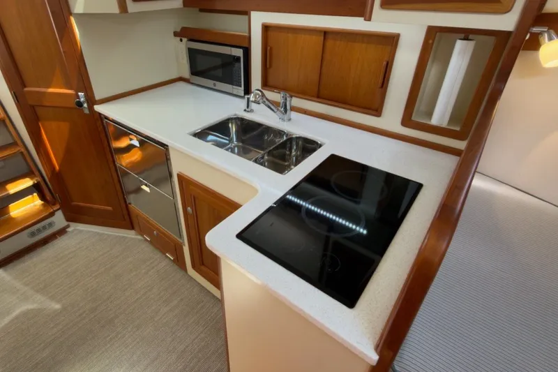 Slide: The Image of Modern kitchen in 2023 Fortier 33 boat with stove, sink, and microwave. - 52