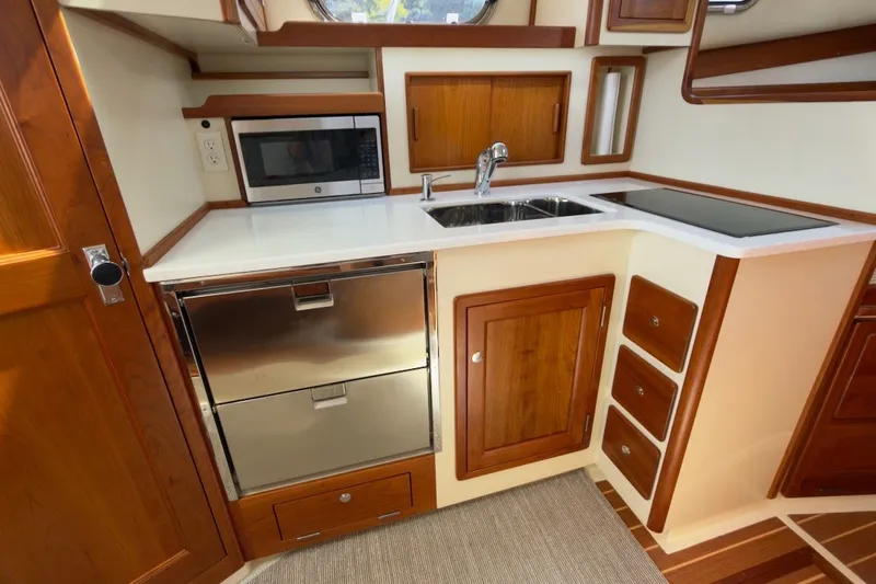 Slide: The Image of Modern kitchen in 2023 Fortier 33 boat with wood cabinetry and stainless steel appliances. - 53