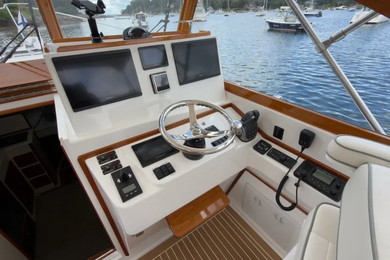 Slide: The Image of 2023 Fortier 33 boat helm with modern navigation equipment and scenic water view. - 30