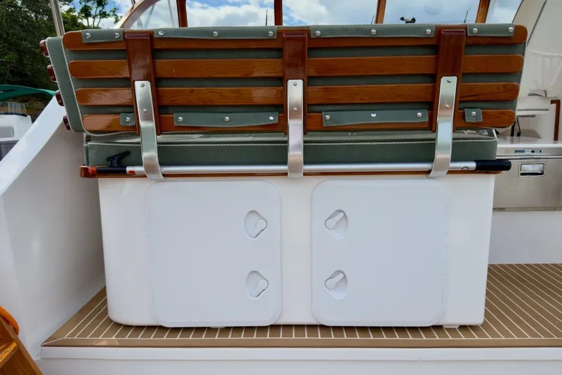 Slide: The Image of 2023 Fortier 33 boat seat with wooden slats and storage compartment. - 36