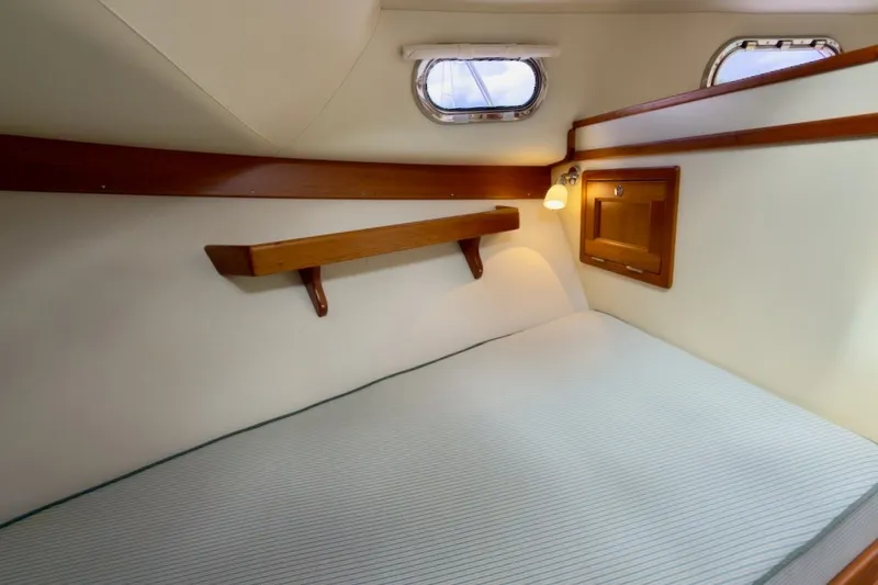 Slide: The Image of Cozy cabin interior of 2023 Fortier 33 boat with wooden accents and porthole windows. - 46