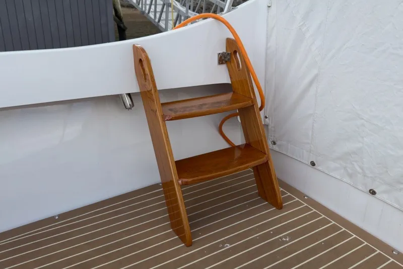 Slide: The Image of Wooden ladder on 2023 Fortier 33 boat deck with striped flooring. - 14