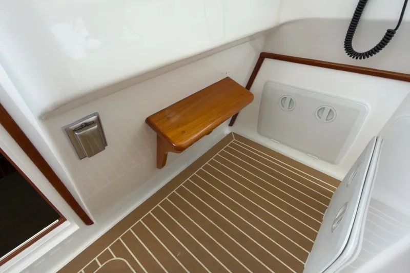 Slide: The Image of 2023 Fortier 33 boat interior with wooden seat and striped flooring. - 35