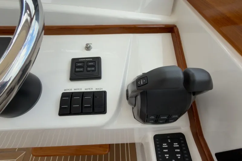 Slide: The Image of Control panel of 2023 Fortier 33 boat with steering wheel and switches. - 33