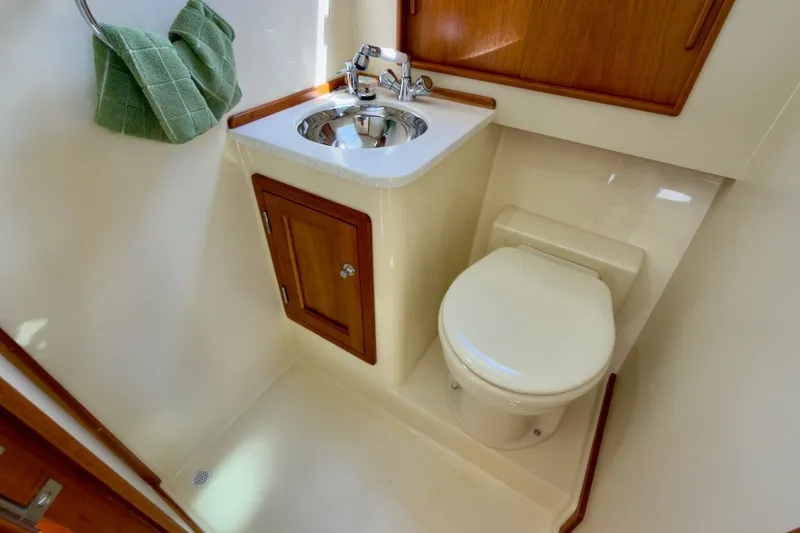 Slide: The Image of Compact bathroom in 2023 Fortier 33 boat with sink, toilet, and wooden cabinetry. - 62