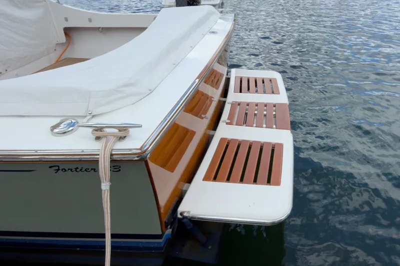 Slide: The Image of 2023 Fortier 33 boat with wooden swim platform on calm water. - 17