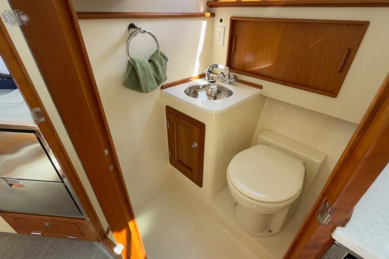 Slide: The Image of 2023 Fortier 33 yacht bathroom with sink, toilet, and wooden cabinetry. - 61