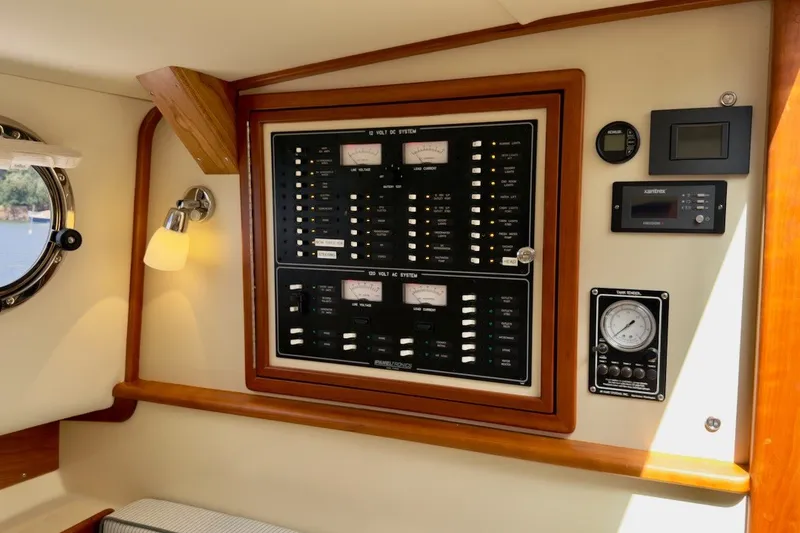 Slide: The Image of Electrical control panel inside 2023 Fortier 33 boat cabin with gauges and switches. - 64