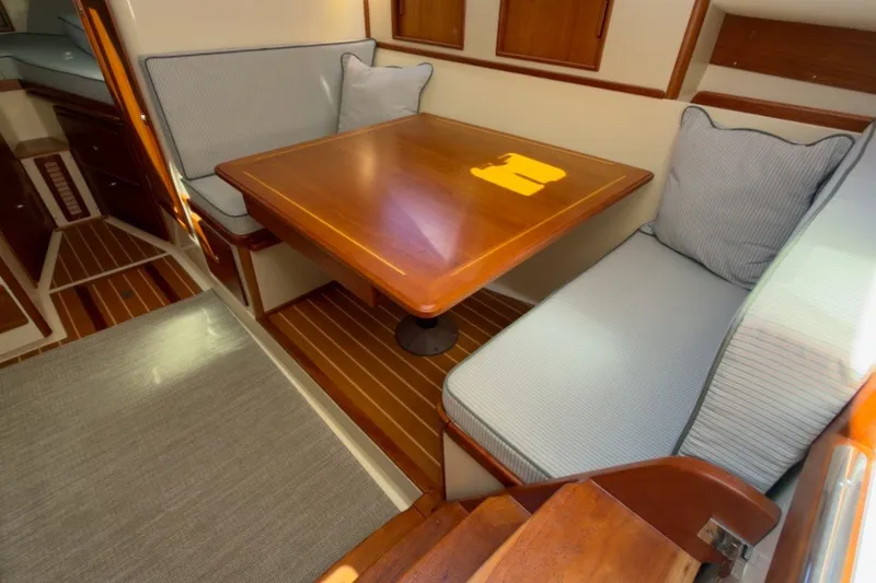 Slide: The Image of Interior of 2023 Fortier 33 boat with wooden table and cushioned seating. - 39