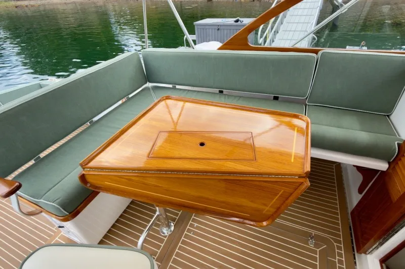 Slide: The Image of Elegant seating area on 2023 Fortier 33 boat with wooden table and green cushions. - 24
