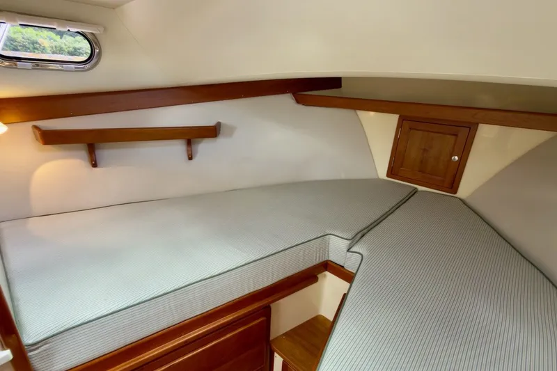 Slide: The Image of 2023 Fortier 33 cabin interior with wooden accents and cushioned seating. - 47