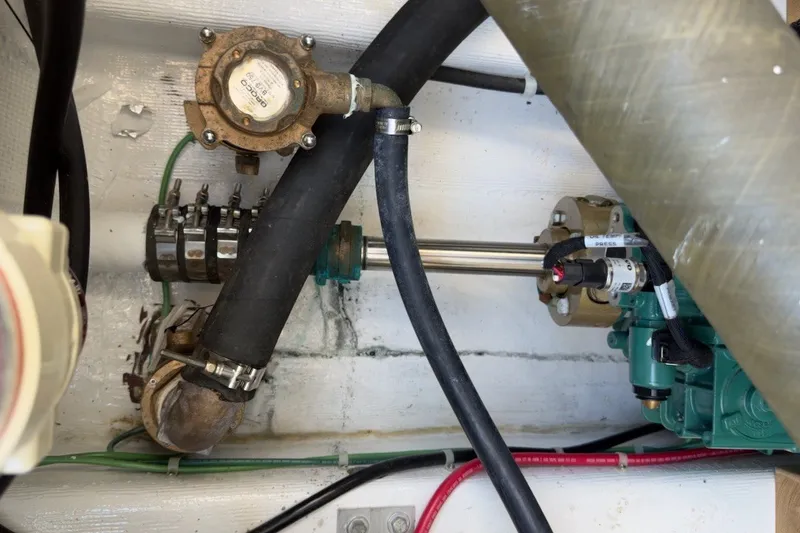 Slide: The Image of Engine compartment of a 2023 Fortier 33 boat, showcasing mechanical components and hoses. - 69