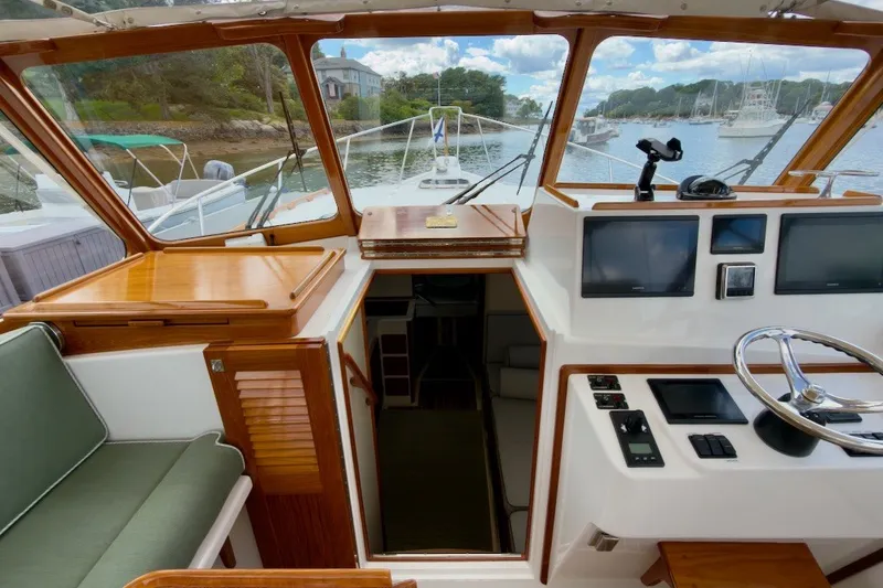 Slide: The Image of Interior view of 2023 Fortier 33 boat cockpit with steering wheel and navigation screens. - 27