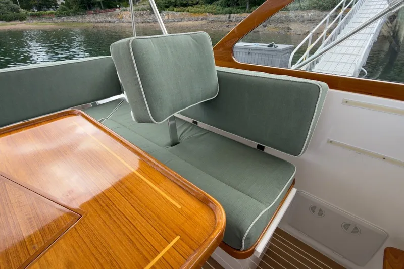 Slide: The Image of Elegant seating area on a 2023 Fortier 33 boat with green cushions and wooden table. - 26