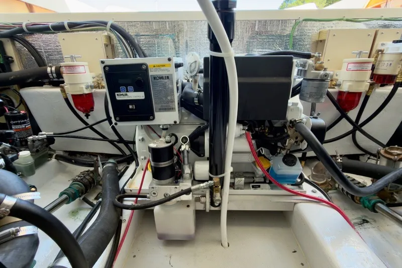 Slide: The Image of Engine compartment of a 2023 Fortier 33 boat, featuring Kohler generator and fuel filters. - 73
