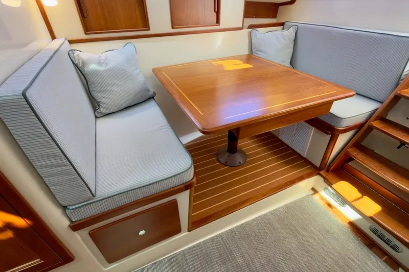 Slide: The Image of 2023 Fortier 33 interior with wooden table, cushioned seating, and elegant design. - 40