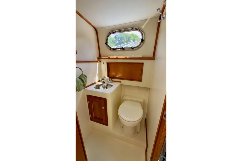 Slide: The Image of Compact bathroom in 2023 Fortier 33 boat with sink, toilet, and wooden cabinetry. - 63