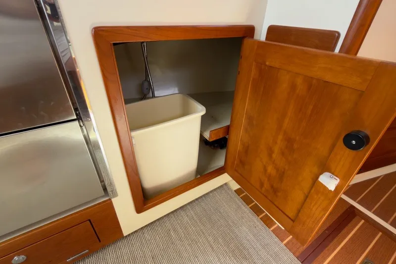 Slide: The Image of Wooden cabinet with open door revealing storage space on Fortier 33, 2023 model. - 60
