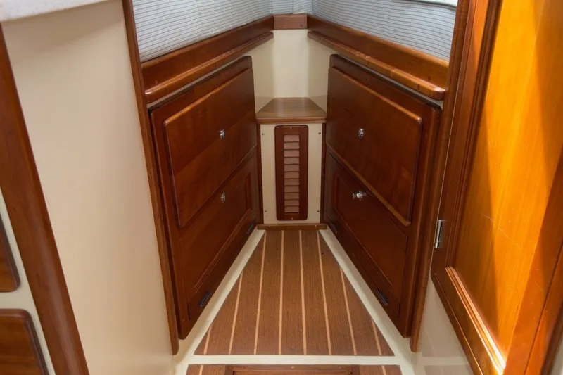 Slide: The Image of 2023 Fortier 33 interior with polished wood cabinetry and striped flooring. - 49