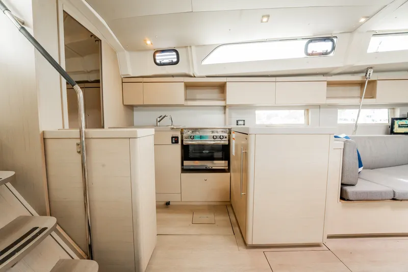 Slide: The Image of Interior of 2020 Beneteau Oceanis 46.1 yacht, featuring modern kitchen and seating area. - 23