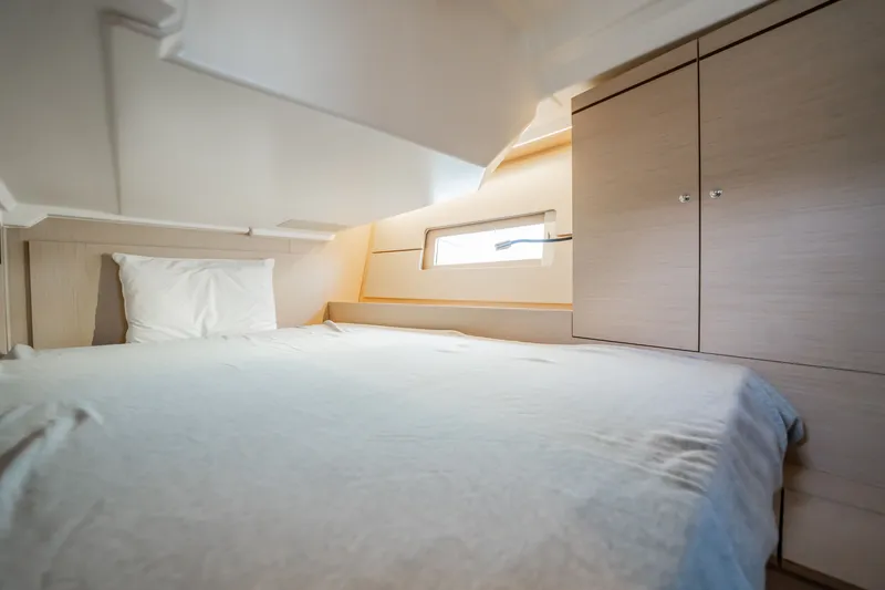Slide: The Image of Interior cabin of 2020 Beneteau Oceanis 46.1 yacht, featuring a cozy bed and wooden cabinetry. - 31
