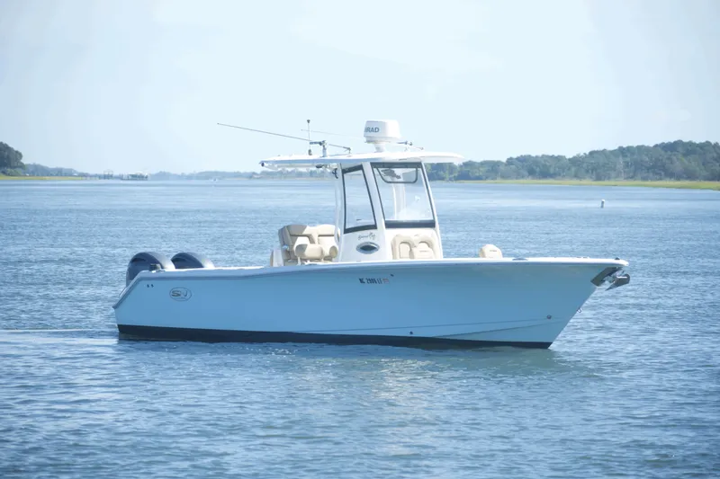 Slide: The Image of 2017 Sea Hunt Gamefish 27FS boat on calm water, clear sky background. - 6