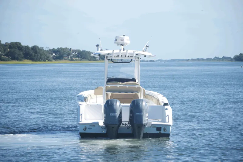 Slide: The Image of 2017 Sea Hunt Gamefish 27FS boat cruising on a calm waterway. - 4