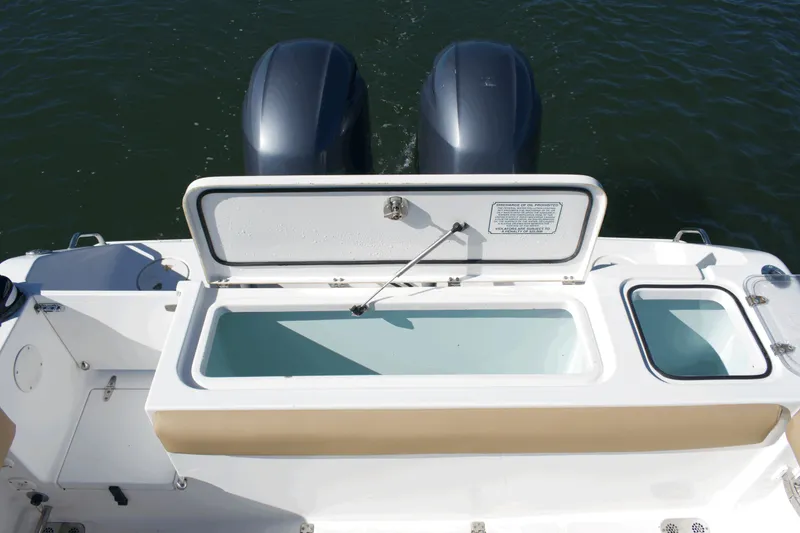 Slide: The Image of 2017 Sea Hunt Gamefish 27FS boat with open storage compartment and dual engines. - 22