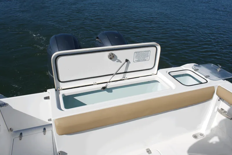 Slide: The Image of 2017 Sea Hunt Gamefish 27FS boat with open storage compartment and twin engines on water. - 21