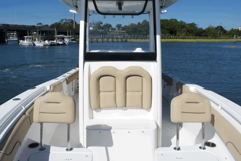 Slide: The Image of 2017 Sea Hunt Gamefish 27FS boat interior with beige seating on a sunny day. - 13