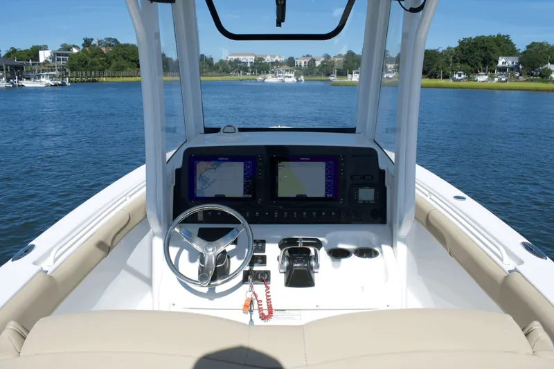Slide: The Image of 2017 Sea Hunt Gamefish 27FS boat dashboard with navigation screens on calm water. - 14
