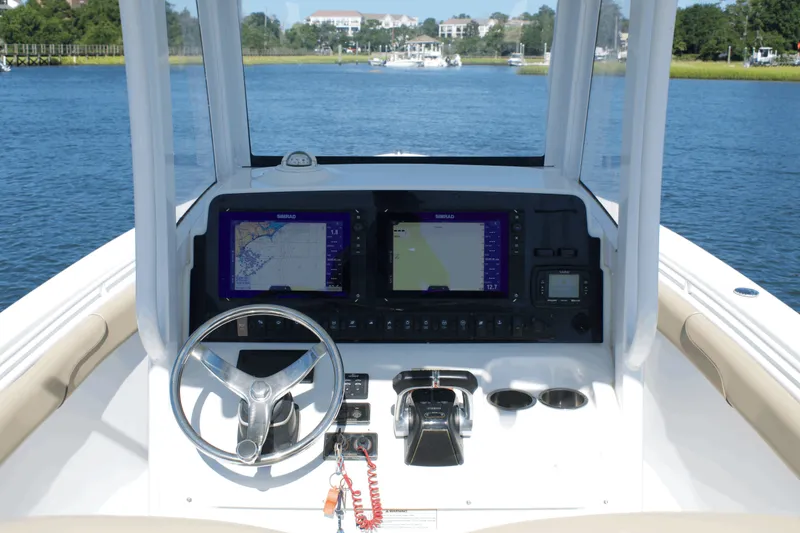 Slide: The Image of 2017 Sea Hunt Gamefish 27FS boat dashboard with navigation screens and steering wheel. - 15