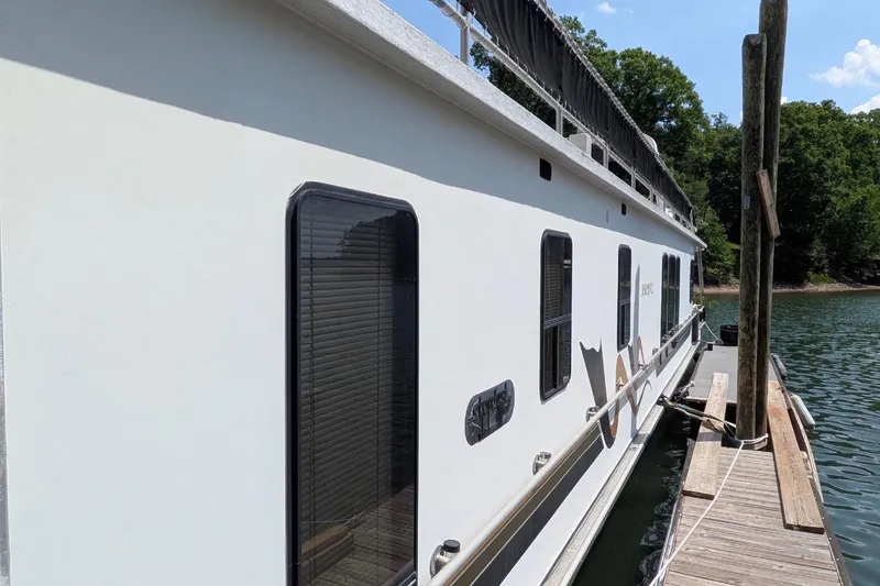 Slide: The Image of 1996 Stardust Cruisers 14.5 x 69 houseboat docked on a serene lake. - 46