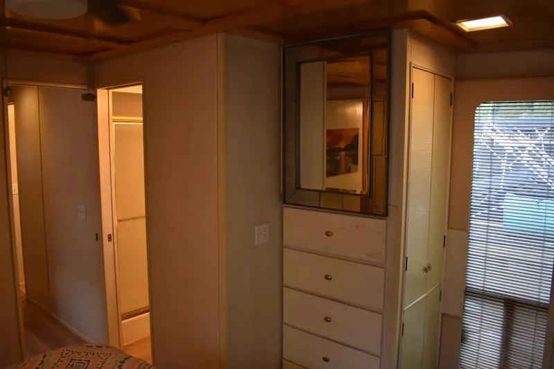 Slide: The Image of Interior of 1996 Stardust Cruisers houseboat with wooden cabinets and mirrored accents. - 18