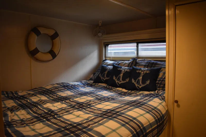 Slide: The Image of Cozy bedroom in 1996 Stardust Cruisers houseboat with nautical-themed decor. - 20