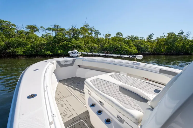 Slide: The Image of 2025 Invincible 33 Open Fisherman boat with sleek seating, cruising near lush mangroves. - 34