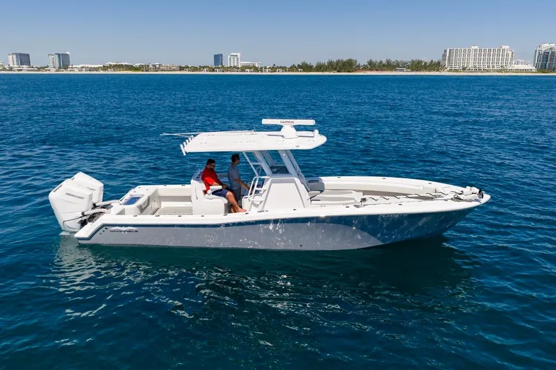 Slide: The Image of 2025 Invincible 33 Open Fisherman boat on clear blue water, city skyline in background. - 55