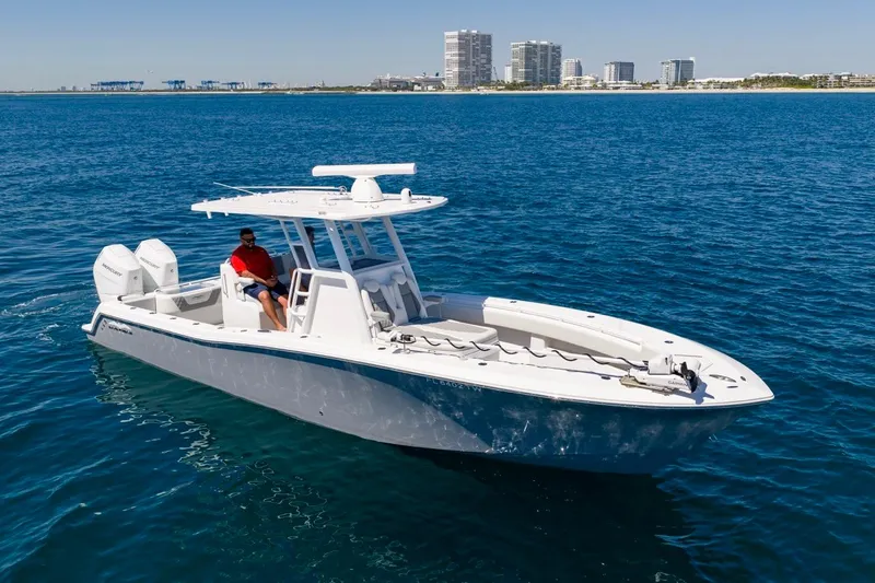 Slide: The Image of 2025 Invincible 33 Open Fisherman boat cruising on blue ocean near city skyline. - 54