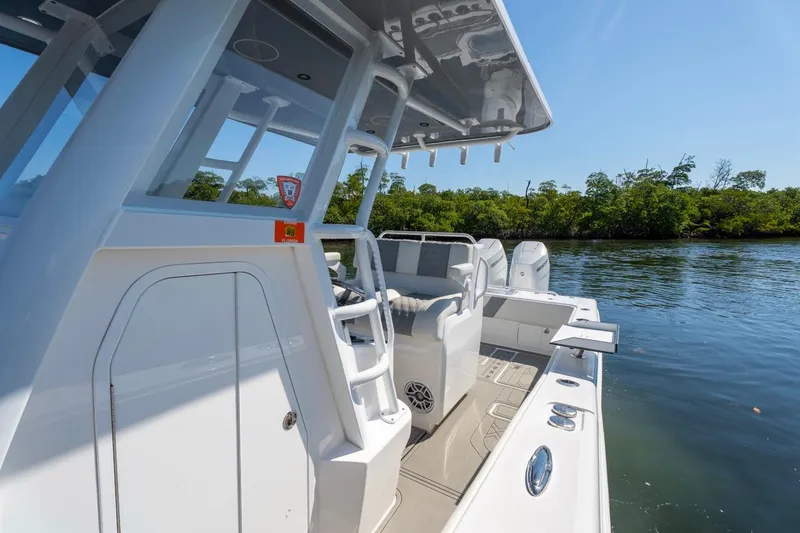 Slide: The Image of 2025 Invincible 33 Open Fisherman boat on calm water, showcasing sleek design and spacious deck. - 18