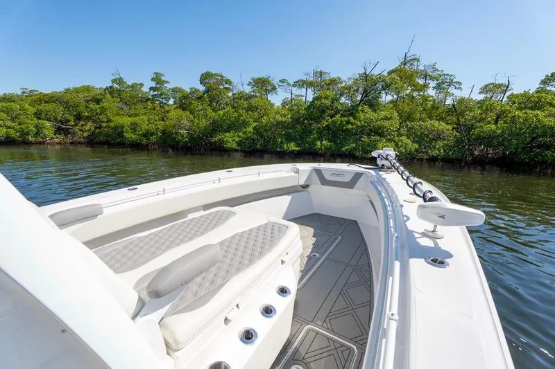 Slide: The Image of 2025 Invincible 33 Open Fisherman boat on calm water near lush greenery. - 36