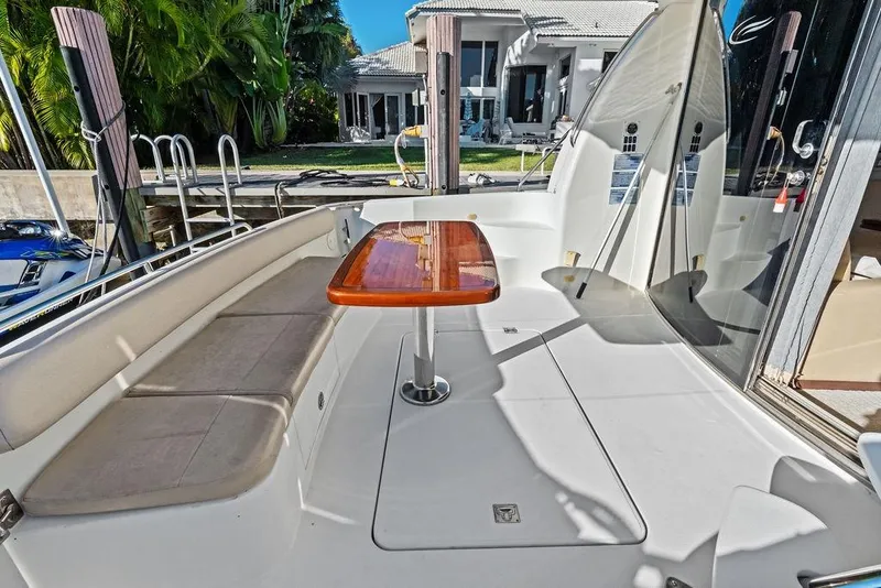 Slide: The Image of 2009 Carver 56 Voyager SE yacht deck with seating and wooden table. - 14