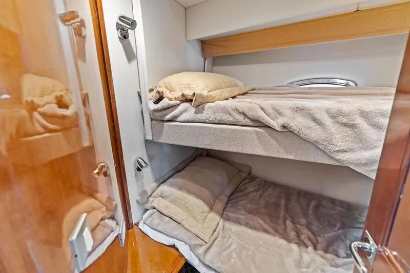Slide: The Image of 2009 Carver 56 Voyager SE yacht interior with cozy bunk beds and wooden accents. - 36