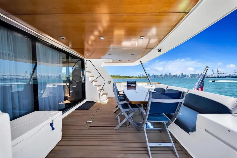 Slide: The Image of Luxurious 2008 Aicon 75 yacht deck with seating, ocean view, and city skyline in the background. - 17