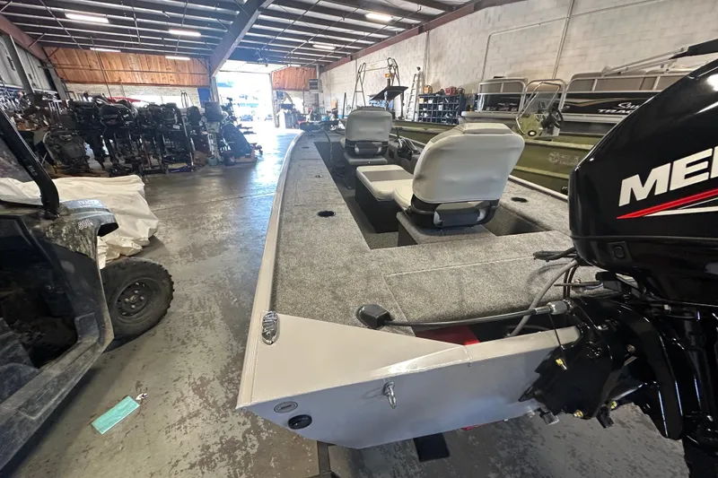 Slide: The Image of 2027 Tracker Panfish 17 boat in warehouse, featuring dual seats and a Mercury outboard motor. - 26