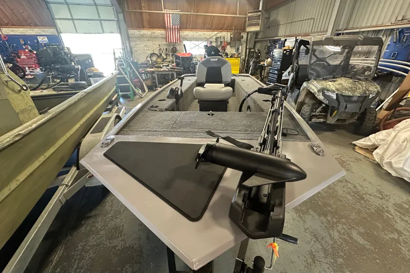 Slide: The Image of 2027 Tracker Panfish 17 boat in a workshop, featuring a trolling motor and spacious interior. - 27