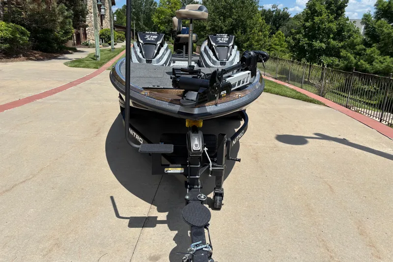 Slide: The Image of 2027 Nitro Z19 XL Pro boat on trailer, parked on driveway with lush greenery. - 2
