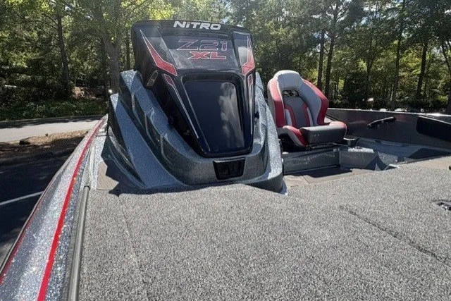 Slide: The Image of 2027 Nitro Z21 XL Pro boat with sleek design and comfortable seating in a wooded setting. - 1
