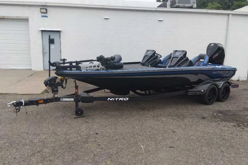 Slide: The Image of 2027 Nitro Z21 XL Pro fishing boat on trailer, parked outside a building. - 5