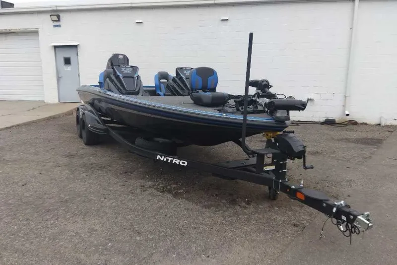 Slide: The Image of 2027 Nitro Z21 XL Pro fishing boat on trailer, parked outside a building. - 2