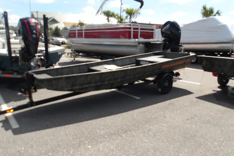 The Image of 2027 Tracker Grizzly 15 Jon boat on trailer in parking lot. - 0